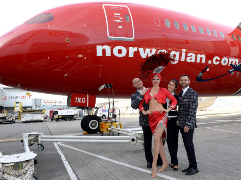 a group of people standing next to a red airplane
